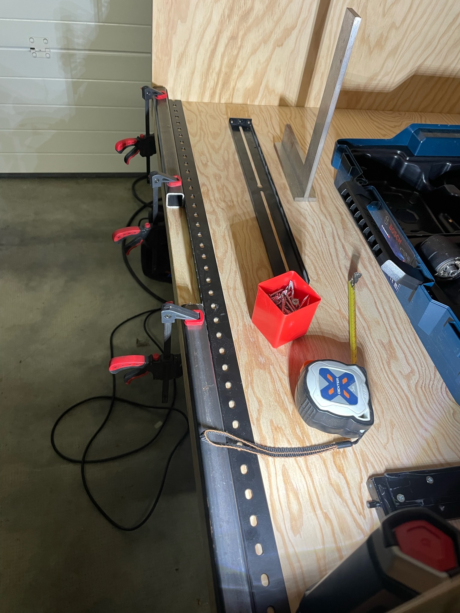 Photo montrant comment le rail a été fixer sur le rack serveur en bois.