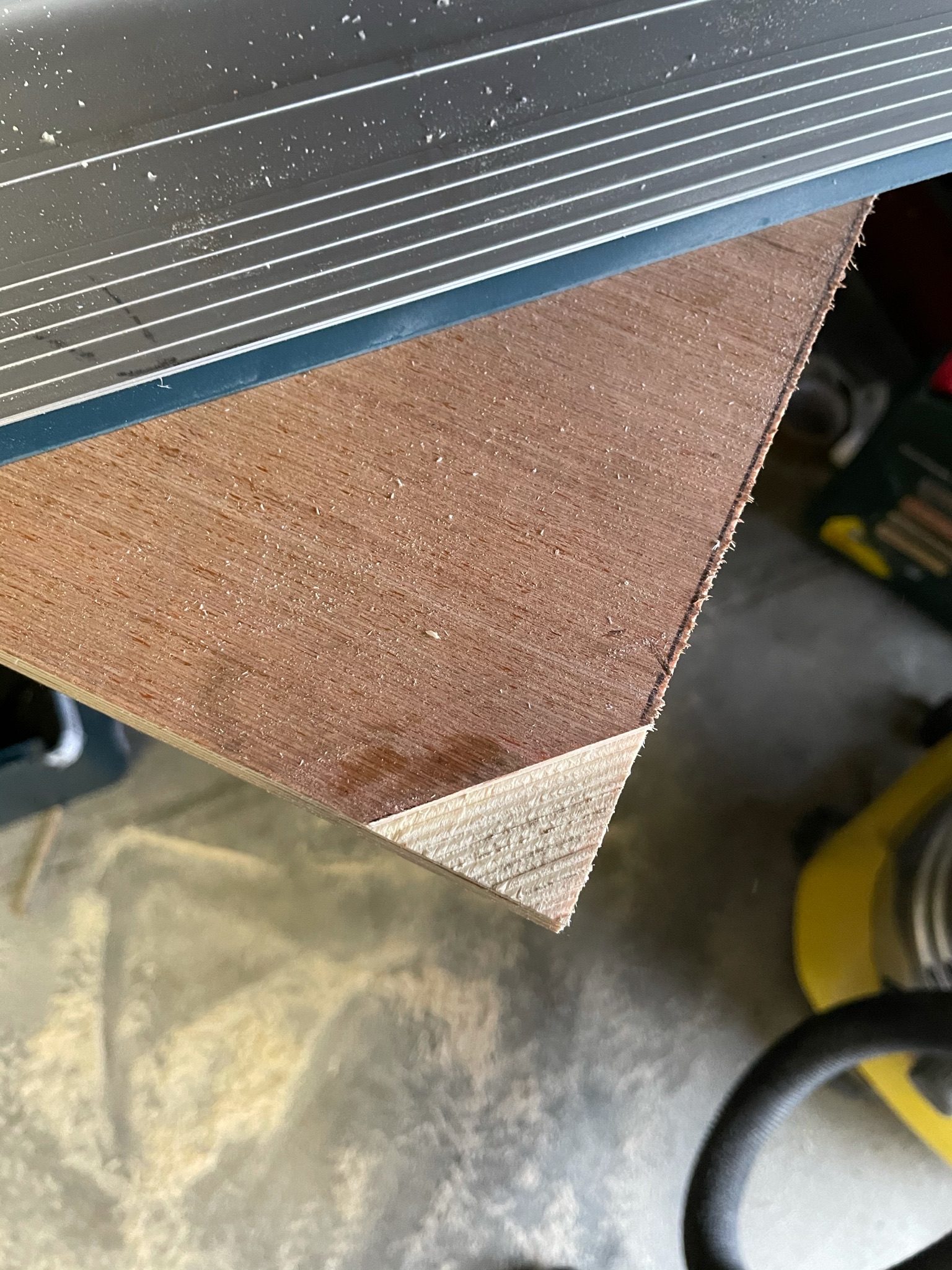 Photo montrant une planche du bas du meuble tv avec l’angle défoncé.