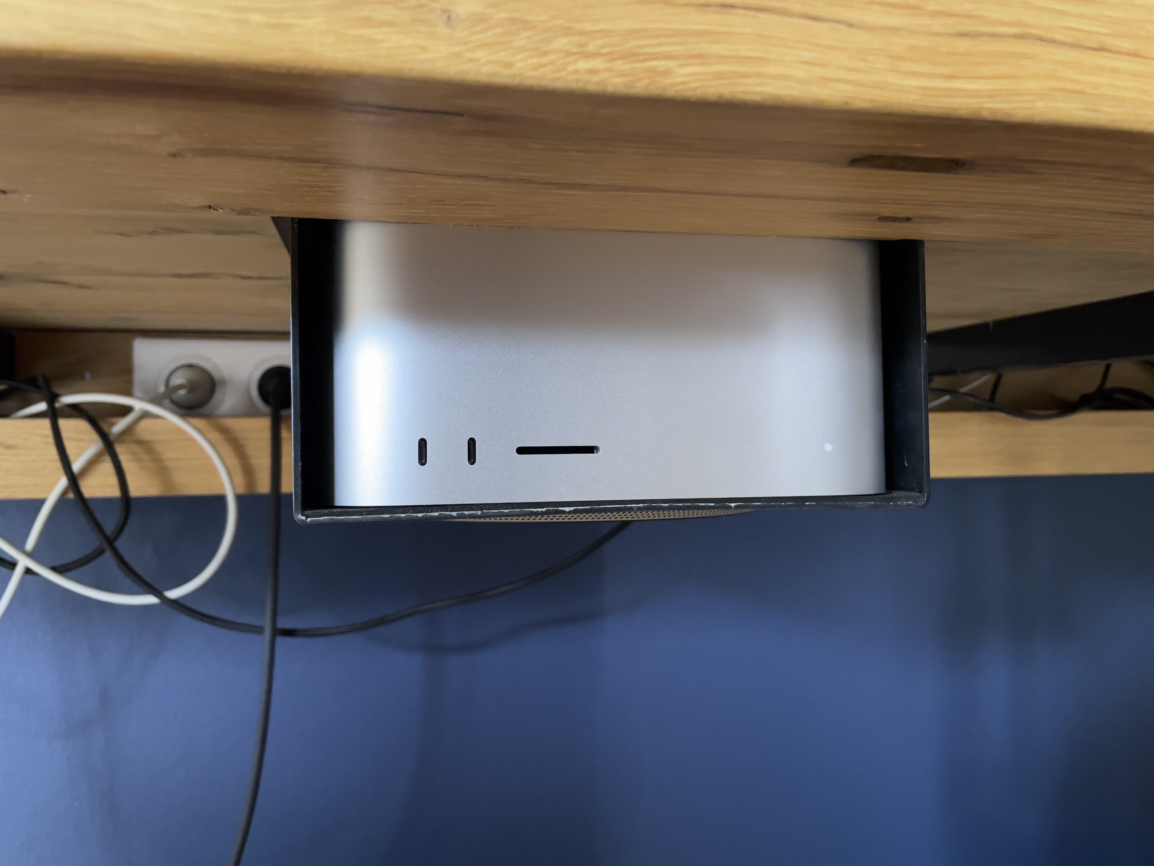 Photo montrant le support de fixation fixer sous le bureau avec le Mac Studio installer vue de face