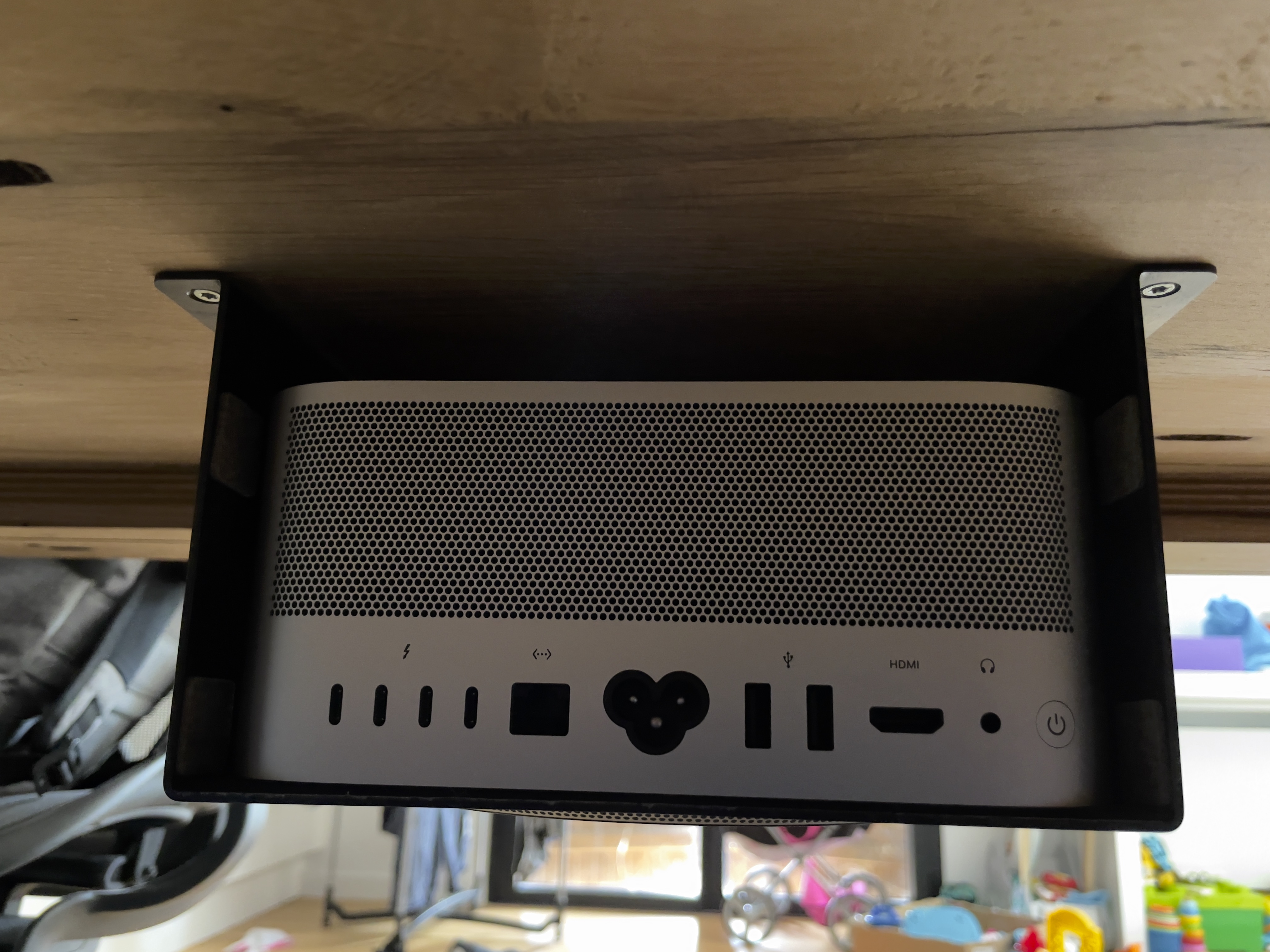 Photo montrant le support de fixation fixer sous le bureau avec le Mac Studio installer vue de l’arrière